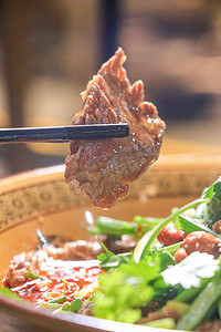 牛摄影照片_美食中午筷子夹香橙牛肉餐厅夹肉摄影图配图