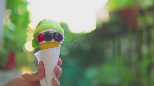 冰淇冰糕雪糕甜筒摄影照片_夏天手拿冰淇淋甜筒雪糕