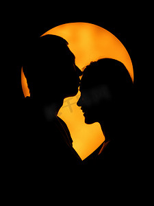 情侣人像剪影晚上一对情侣黄色光晕上亲吻额头剪影摄影图配图