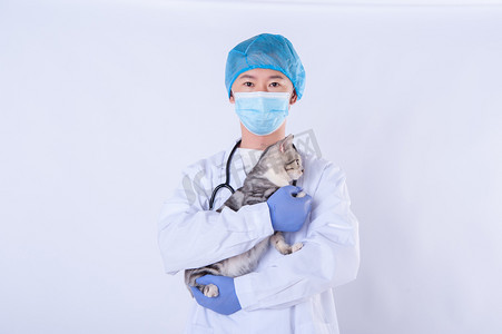医生和猫白天男医生和猫室内双手抱猫在胸前摄影图配图