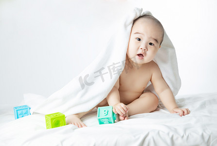 婴儿白天玩耍的婴儿室内床上玩玩具摄影图配图