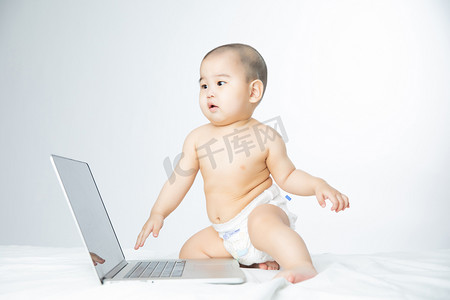 婴儿启蒙教育白天可爱搞笑婴儿室内玩电脑摄影图配图