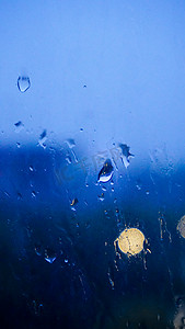 光斑水纹摄影照片_下雨天气夜晚雨滴室内玻璃窗大雨摄影图配图