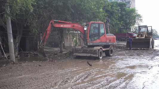 洪灾摄影照片_洪水后清理淤泥洪水的挖掘机