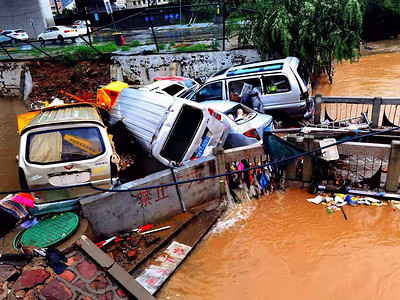 暴雨后洪水冲坏的车辆堆积在一起摄影图配图
