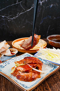 美食摄影照片_美食中午北京烤鸭室内特色名吃摄影图配图