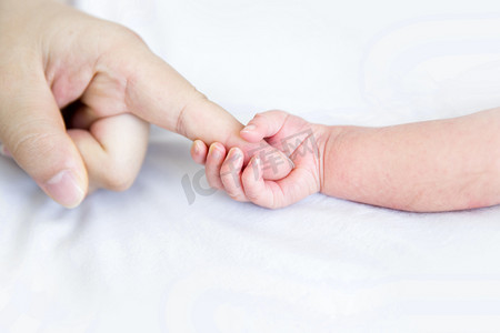 婴儿手势摄影照片_婴儿手势大手拉小手婴儿母婴小宝宝摄影图配图