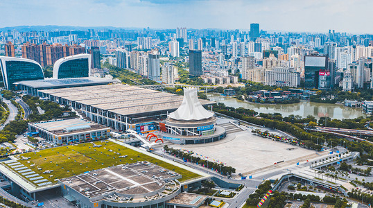 城市建筑楼群摄影照片_城市中午广西南宁国际会展中心航拍路旁无人机摄影图配图