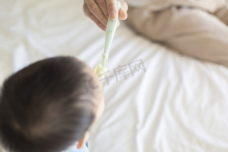 辅食摄影照片_宝宝白天爸爸和宝宝房间里喂辅食摄影图配图