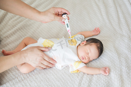 婴儿护理母婴三胎量体温人像摄影图配图