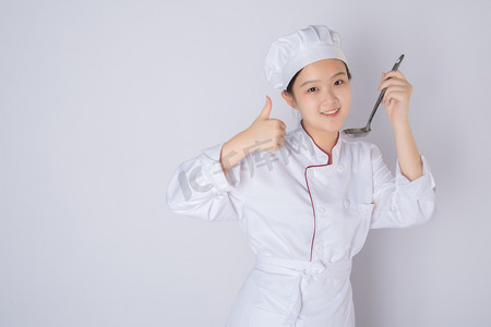 年轻女厨师白天一个女厨师白背景开心点赞手势摄影图配图