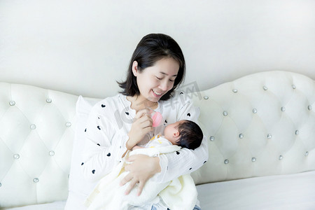 婴儿护理母婴亲子互动给婴儿喂奶新生摄影图配图