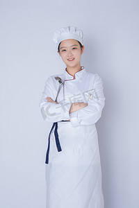 年轻女厨师白天一个女厨师白背景双手交叉抱在胸前摄影图配图