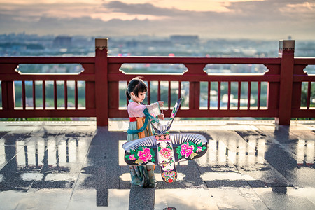 中国红摄影照片_放风筝得女孩傍晚女孩儿童山顶放风筝摄影图配图