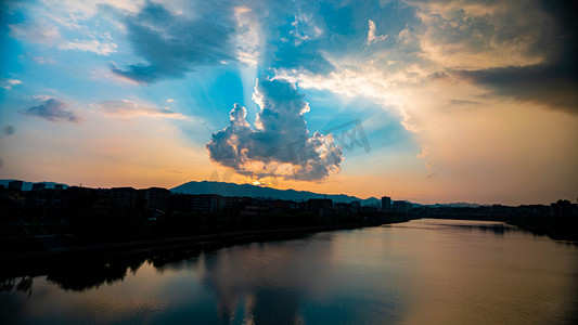 黄昏落日耶稣光夏天的黄昏落日河边火烧云摄影图配图