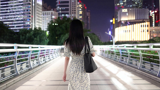 人物行走摄影照片_都市女性夜晚在天桥独自行走的背影