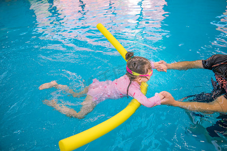 水下运动摄影照片_暑期培训白天女童游泳馆训练摄影图配图