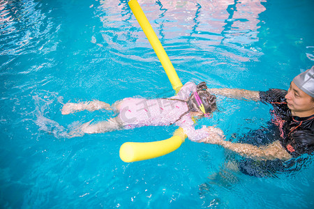 水下运动摄影照片_人物白天女孩室内游泳馆训练摄影图配图