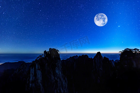 中秋月亮中秋摄影照片_节日早上月亮山区飘动摄影图配图