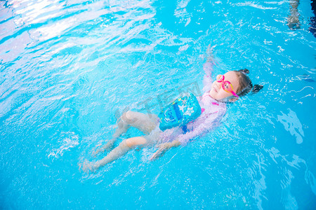水下运动摄影照片_人物白天女童游泳馆仰泳摄影图配图
