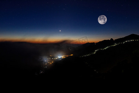 中秋节摄影照片_中秋节黑夜月亮山区飘动摄影图配图