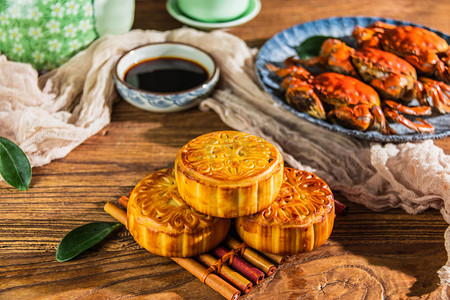 大闸蟹摄影照片_中秋节美食中午月饼和大闸蟹餐桌美食摄影图配图