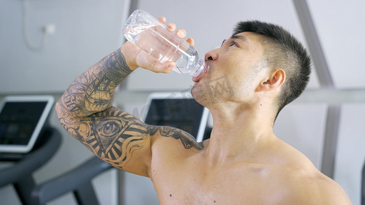 增肌摄影照片_健硕男运动员补充水分喝水营养健身教练
