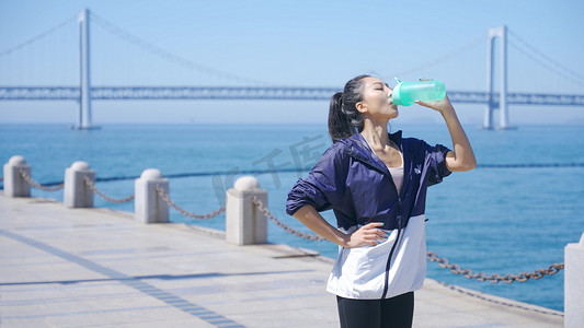 美女派对海报摄影照片_美女湖边晨练运动休息喝水补充水分