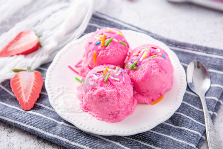 球冰淇淋摄影照片_美食夏天草莓冰淇淋球室内白盘子上摄影图配图