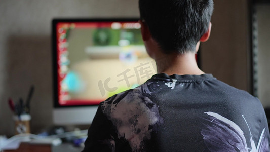 青少年男生打游戏玩电脑游戏背影