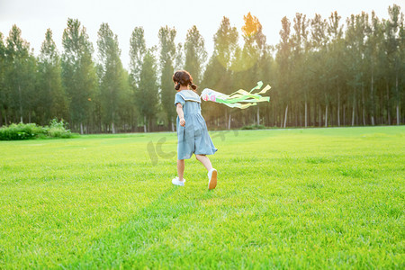 奔跑女孩摄影照片_人物夏天女童草地奔跑摄影图配图