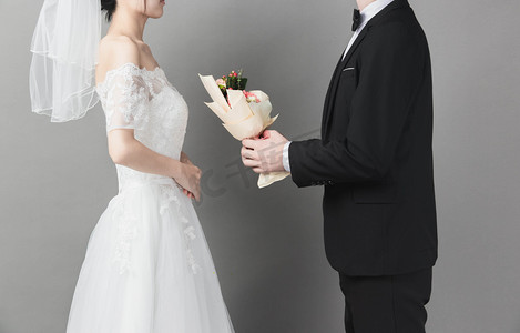 婚礼中式路引摄影照片_婚礼人物白天新郎新娘礼堂献花摄影图配图