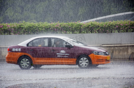 白天户外教练车在暴雨中行驶摄影图配图