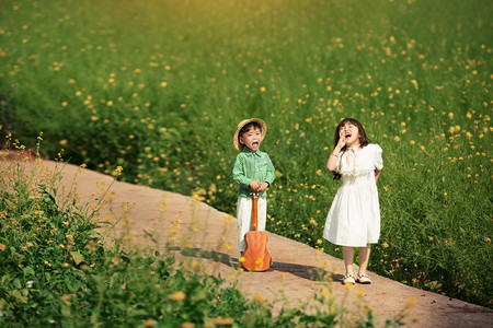 儿童男孩女孩夏天在油菜花地愉快的玩耍摄影图配图
