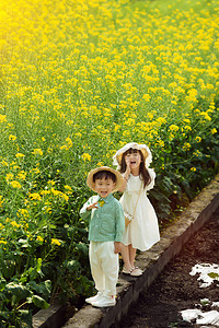 愉快的孩子走在油菜花田里开心的笑摄影图配图