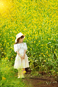 春分出游摄影照片_唯美治愈的小女孩在油菜花田看远方摄影图配图
