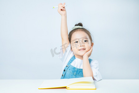 升学简历摄影照片_教育上课白天可爱小女孩室内举手摄影图配图