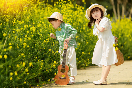 春天在油菜花田游玩的孩子摄影图配图