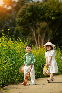 春分出游摄影照片_温馨的两个孩子在油菜花田游玩摄影图配图