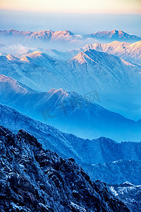 冬季手抄报边框摄影照片_冬日旅行白昼雪山山区飘动摄影图配图