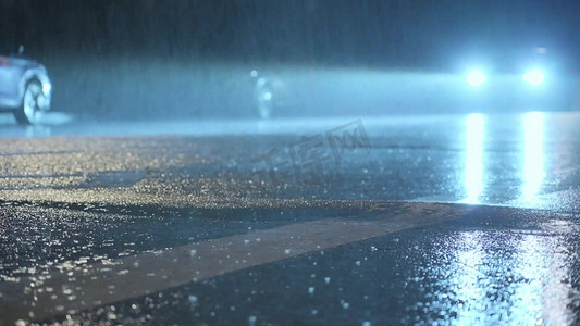 汽车美容培训摄影照片_夜晚街道暴雨中行驶的汽车摄影图
