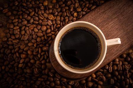 咖啡豆摄影照片_美食饮料夜晚美式咖啡咖啡豆室内木盘上摄影图配图
