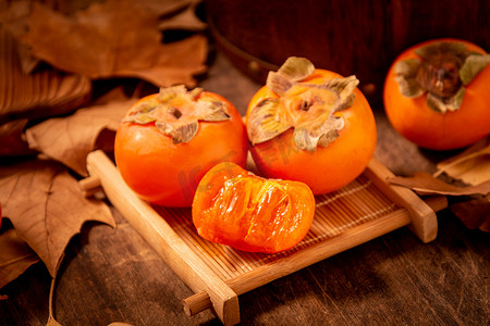 秋季美食摄影照片_美食白天柿子室内木桌上摄影图配图