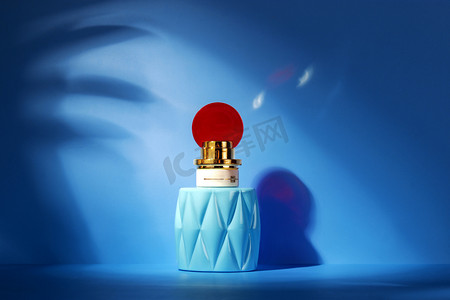 美妆产品棚拍女士香水蓝色瓶子蓝色背景摄影图配图