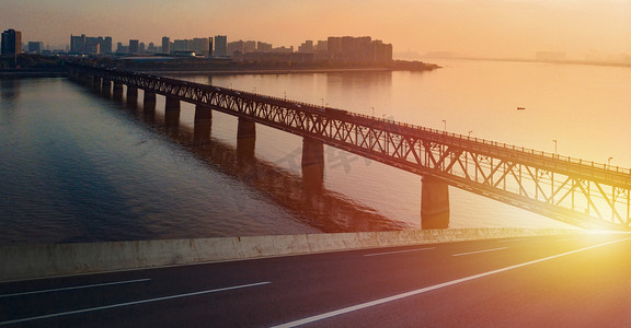 城市跨江大桥夕阳路面夕阳大桥路面大桥城市摄影图配图