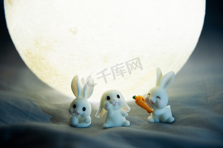 中秋节夜晚月亮和玉兔在月亮下开心玩耍摄影图配图