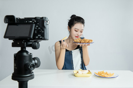 直播设备前闻美食香味的吃播平拍摄影图配图