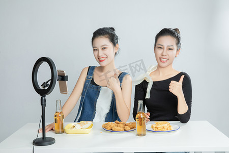 吃货的世界摄影照片_美食吃播主播两个美女平拍摄影图配图