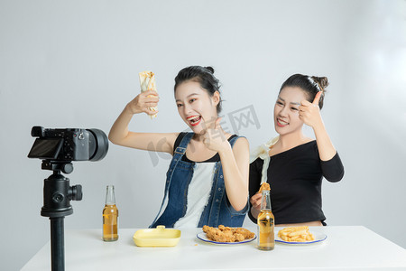 两个美食主播直播吃薯条摄影图配图