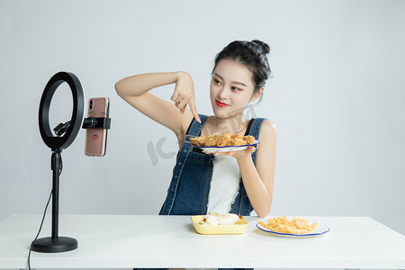 吃货的世界摄影照片_直播间讲解美食的吃播平拍摄影图配图